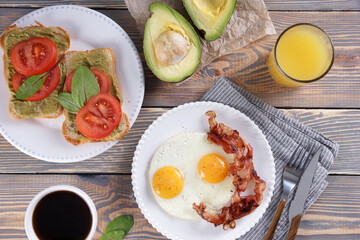 Breakfast with fried eggs and bacon and sandwiches with guacamole sauce