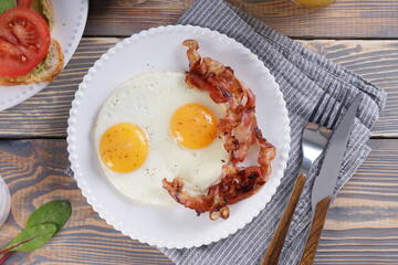 Breakfast with fried eggs and bacon and sandwiches with guacamole sauce