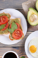 Breakfast with fried eggs and bacon and sandwiches with guacamole sauce