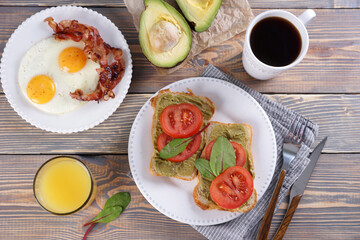 Breakfast with fried eggs and bacon and sandwiches with guacamole sauce