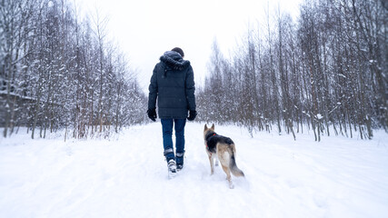 Fototapeta na wymiar Walking in the park in winter with a dog