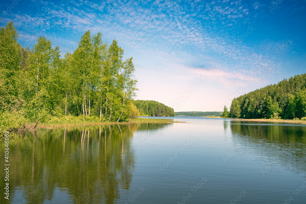 Wall mural panoramic landscape on a sunny day on the river with the sky in the clouds and the reflection in the