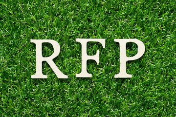 Wood alphabet letter in word RFP (Abbreviation of request for proposal) on green grass background