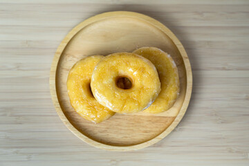 Tasty original icing sugar donuts served on wooden plate. Bakery food close-up photo.