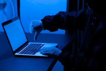 Scammer using laptop computer for hacking or steal data at night in office. Identity theft,...
