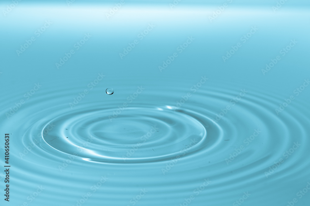 Wall mural drop of water drop to the surface. waves on the surface of the water from a collision