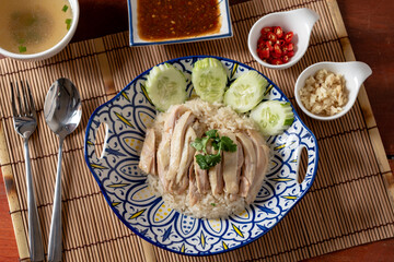 Top view of traditional Chinese food that is Hainanese chicken rice with side dishes on wooden table