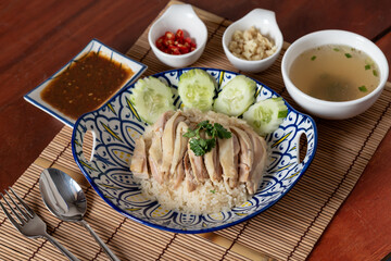 Top view of traditional Chinese food that is Hainanese chicken rice with side dishes on wooden table