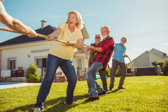 Senior people having fun competing in rope pulling
