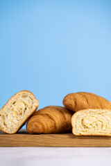fresh croissants on wooden board. Сroissants  on a blue background