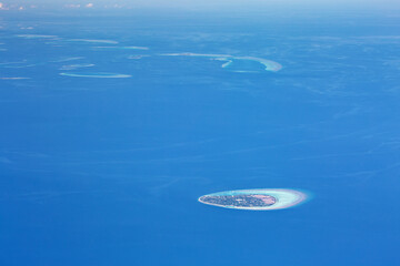 Fototapeta na wymiar Window view from airplane on maldivian atoll with islands
