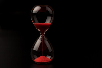Crystal hourglass on black background as a concept of passing time for business term, urgency and...
