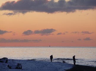 Figures on the shore at Prestwick, Ayrshire at sunset on a cold winter's day