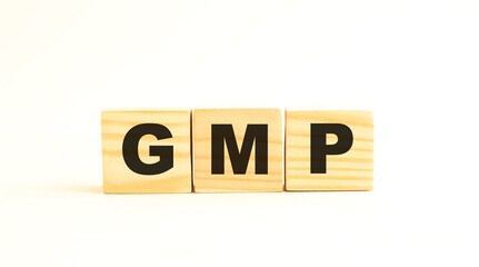 The word GMP. Wooden cubes with letters isolated on white background.