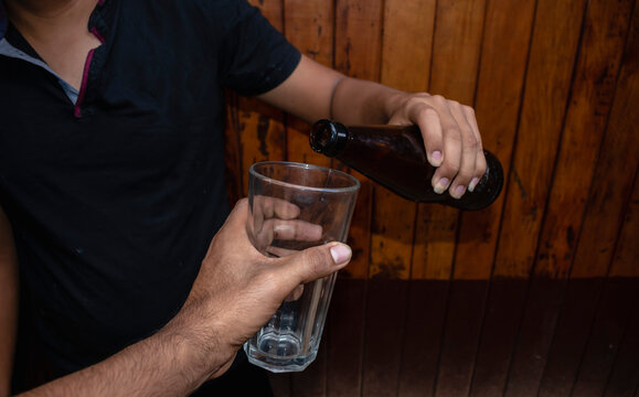 man pouring a beer into a glass: stock photo