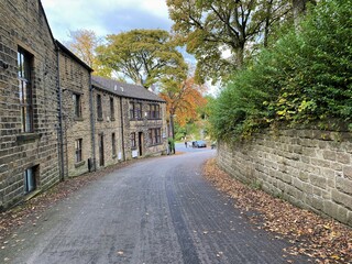 View along, Jew Lane, with stone cottages, old trees, and a cloudy sky in, Oxenhope, Keighley, UK