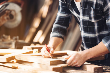 Confident wood worker expert. Young man working at factory. Skilled carpenter