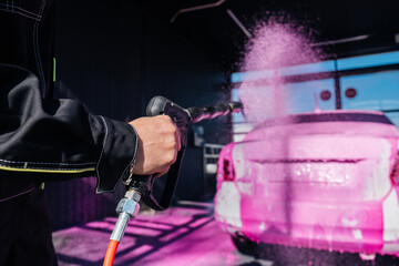 car wash with a spray of pink foam from a pistol