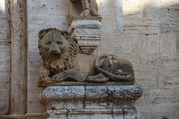 Raffigurazione di un leone alla base di una colonna sulla facciata della Pieve dei Santi Quirico e Giulitta a San Quirico d'Orcia