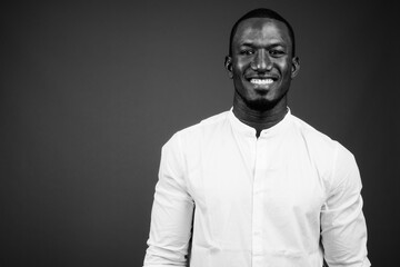 Handsome African businessman against brown background shot in black and white