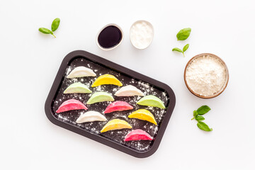 Top view of colorful raw dumplings on baking sheet