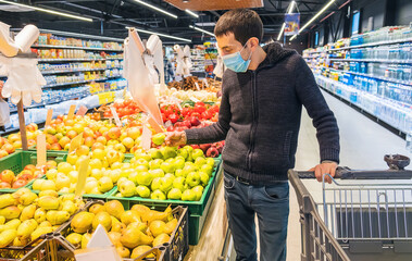 A man buys groceries at the supermarket. Selective focus.