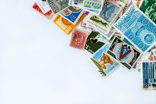 Corner border made of multicolored postage stamps collection from different countries on white background