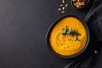 Pumpkin soup garnish microgreens on black background. View from above. Space for text.