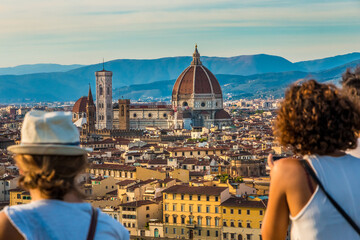 Two women admiring the panoramic view from the square Piazzale Michelangelo to the historic heart...
