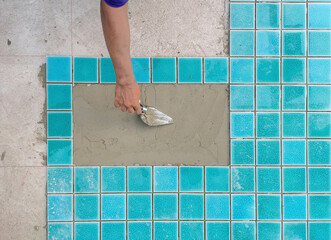Technicians are installing swimming pool tiles.