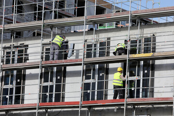drei bauarbeiter auf einer baustelle