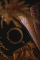 autumn still life a cup of coffee on the table a stack of knitted sweaters