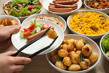 Woman taking food from buffet table, closeup