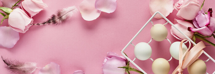 Eggs in white ceramic holder and flowers on pink background. Mock up. Spring Happy Easter holiday card. Top view.