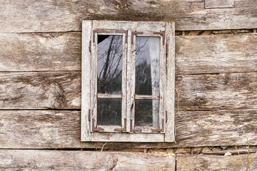 Window on a wooden wall of the old house