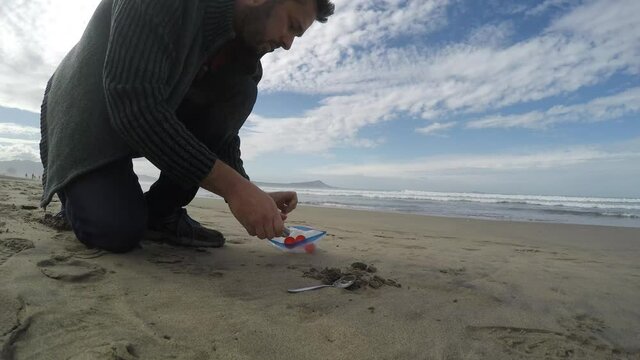 Field scientist sampling sand on a beach