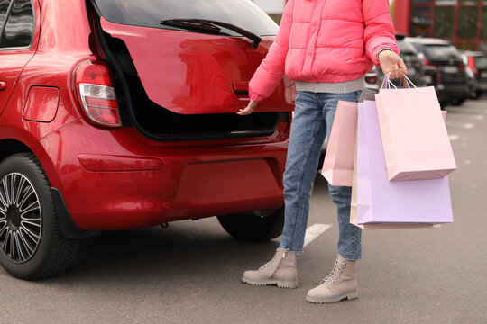 Woman with shopping bags near her car outdoors, closeup