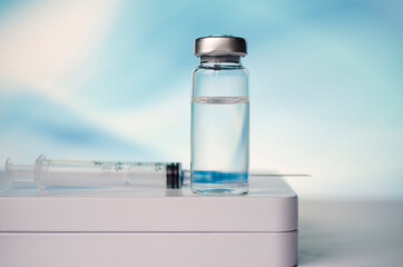 Ampoules and syringe with Covid-19 vaccine on a laboratory table.For the prevention, immunization and treatment of coronavirus infection.Infectious medicine concept. With copy space