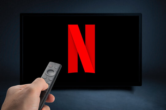 USA, NEW YORK February 2, 2021: Close up of Nvidia Sheild TV Remote in Hand and TV Screen with NEW Netflix Logo, Netflix is a well known global provider of streaming movies