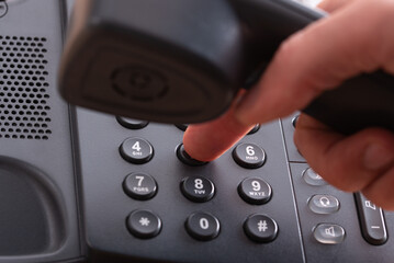 Finger dialing a phone number on landline telephone