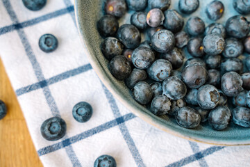 Blueberries are scattered on a white towel