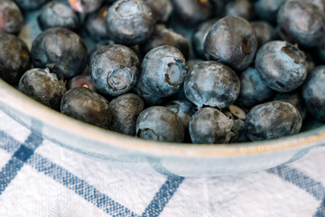 Blueberries are scattered on a white towel