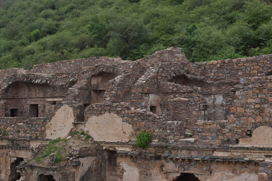 Ruins of an old building near a green forest in Bhangarh village, Rajgarh Alwar, Rajasthan, India