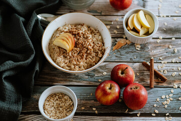 Naklejka na ściany i meble A porridge bowl with apples and cinnamon, food still life, healthy breakfast