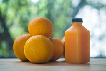 Fresh orange juice in bottle and oranges