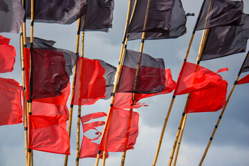 czerwono czarne flagi na tle niebieskiego nieba na plaży w porcie nad polskim morzem bałtyckim