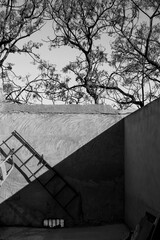 Old metal ladder leaning on concrete wall