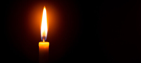 Close up single candle light and flame on black background