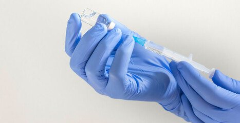 Doctor hands holding a vaccine bottle and syringe,beginning of worldwide mass vaccination for coronavirus COVID-19,influenza or flu,world immunization concept. Selective focus