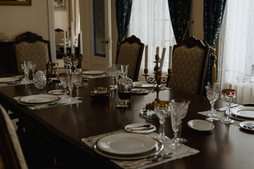 Fototapeta na wymiar Served table for dinner. Table, candles, glasses. A restaurant. Dining room in the mansion.